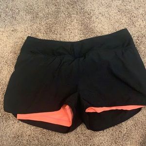 Black shorts with coral spandex under